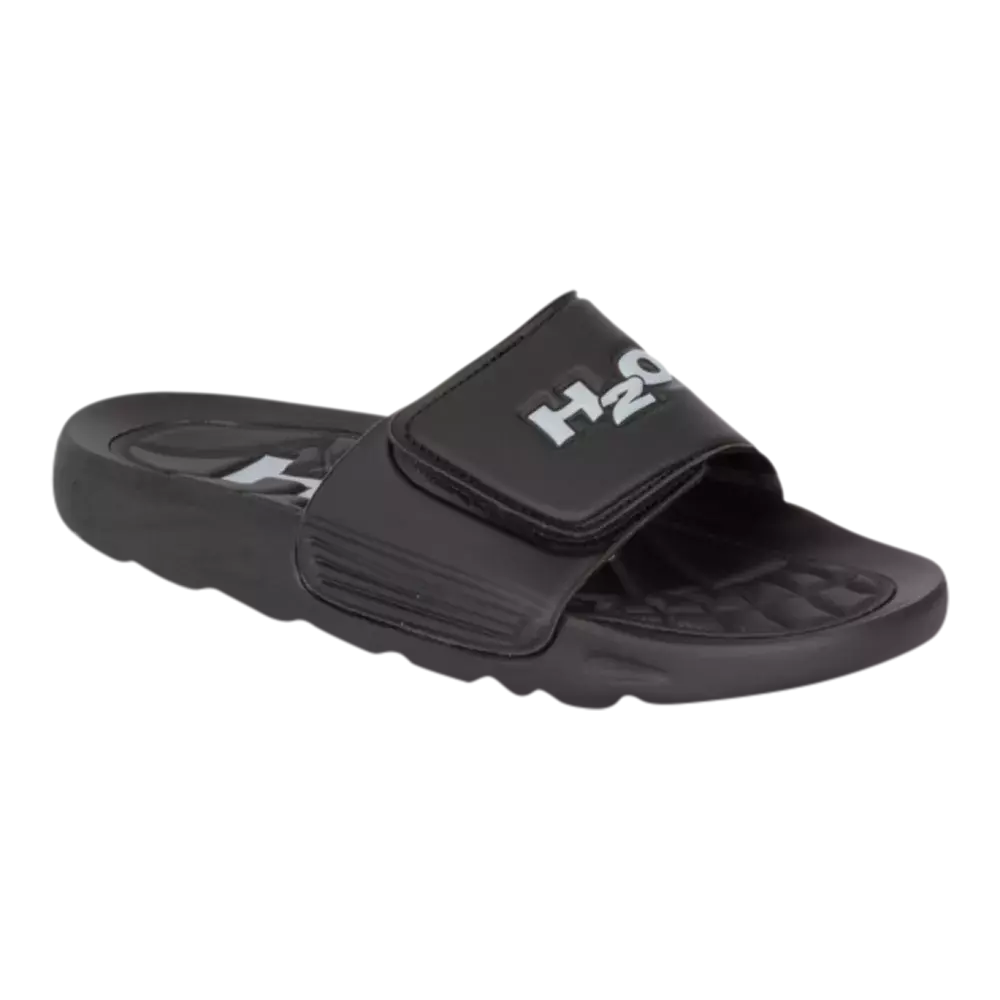 Sort badesandal i sporty design med en bred, justerbar velcrorem prydet af hvid "H2O"-logo. Sålens profil er let oppustet og har en mønstret, masserende indersål for bedre greb og komfort. Sandalen virker lavet af vandafvisende syntetisk materiale, ideel til strand, pool eller afslappet hjemmebrug. Enkel og funktionel konstruktion gør den nem at tage af og på samt let at rengøre.