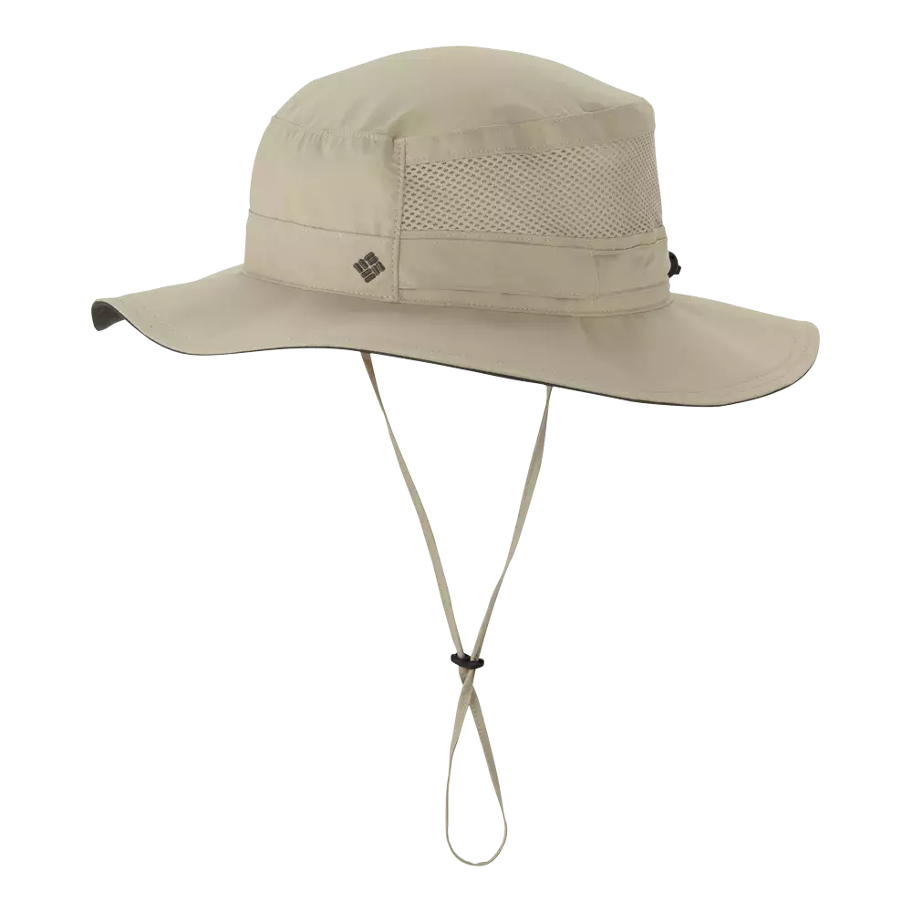 Billedet viser en beige outdoor-hat med bred skygge og lav profil. Hatten har mesh-indsatser rundt om kronen for ventilation, en stivrandet skygge og justerbar hakestrop med snor og stopper. Simpelt design med diskret logo på siden, ideel til vandreture, strand eller havearbejde, hvor let vægt og solbeskyttelse er ønsket. Den neutrale farve gør den nem at kombinere med forskelligt outdoor-udstyr.