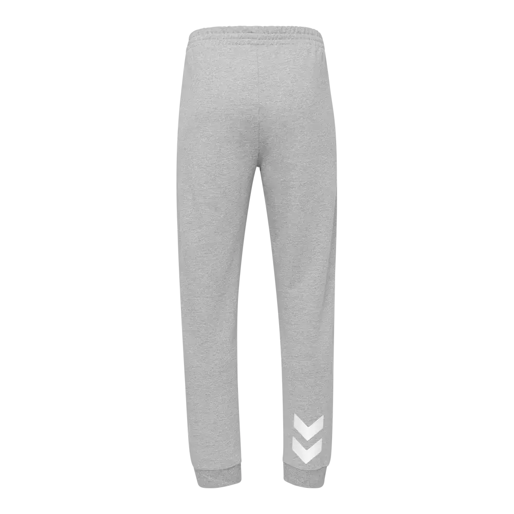 Lysegrå joggingbukser i blødt sweatstof, vist bagfra. Bukserne har en elastisk talje, let tætsiddende pasform og ribkant ved anklerne for et sporty look. Materialet ser varmt og behageligt ud til hverdagsbrug eller træning. På det ene ben, nær anklen, er der tre hvide chevron-pile som diskret detalje. Enkel og funktionel stil med fokus på komfort.