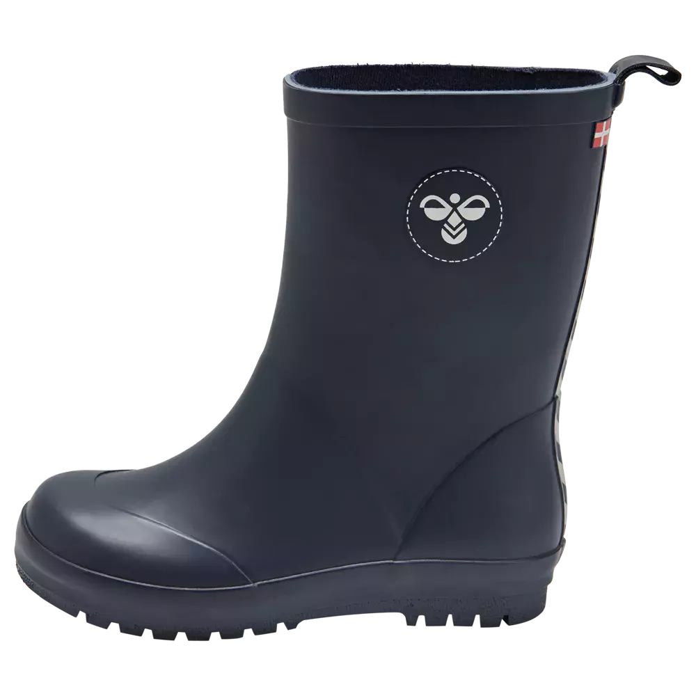 Blå gummistøvle i midtlængde med enkelt og moderne design. Støvlen er mørkeblå med rund snude, profilssål og let runde former, der giver et robust, vandtæt udtryk. På skaftet ses et hvidt bi-logo omgivet af en stikket cirkel, og en lille træksløjfe med dansk flag sidder bagpå. Inderfor er et blødt for, der antyder komfort og varmt, praktisk brug i våde omgivelser.