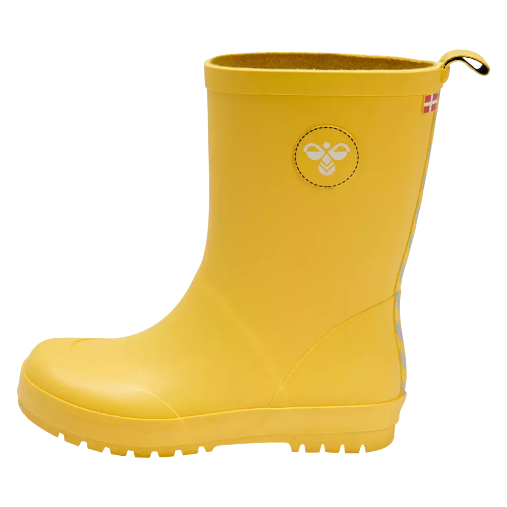 Gul gummistøvle i barnestørrelse, enkel og funktionel. Støvlen har en glat, mat overflade, robust profil sål med mønster for godt greb, og en lille løkke bagpå til at trække den på. På siden ses et diskret insektlignende logo i hvidt og en lille dansk flagetiket. Ideel til vådt vejr, leg i mudder og tryg udendørsbrug.