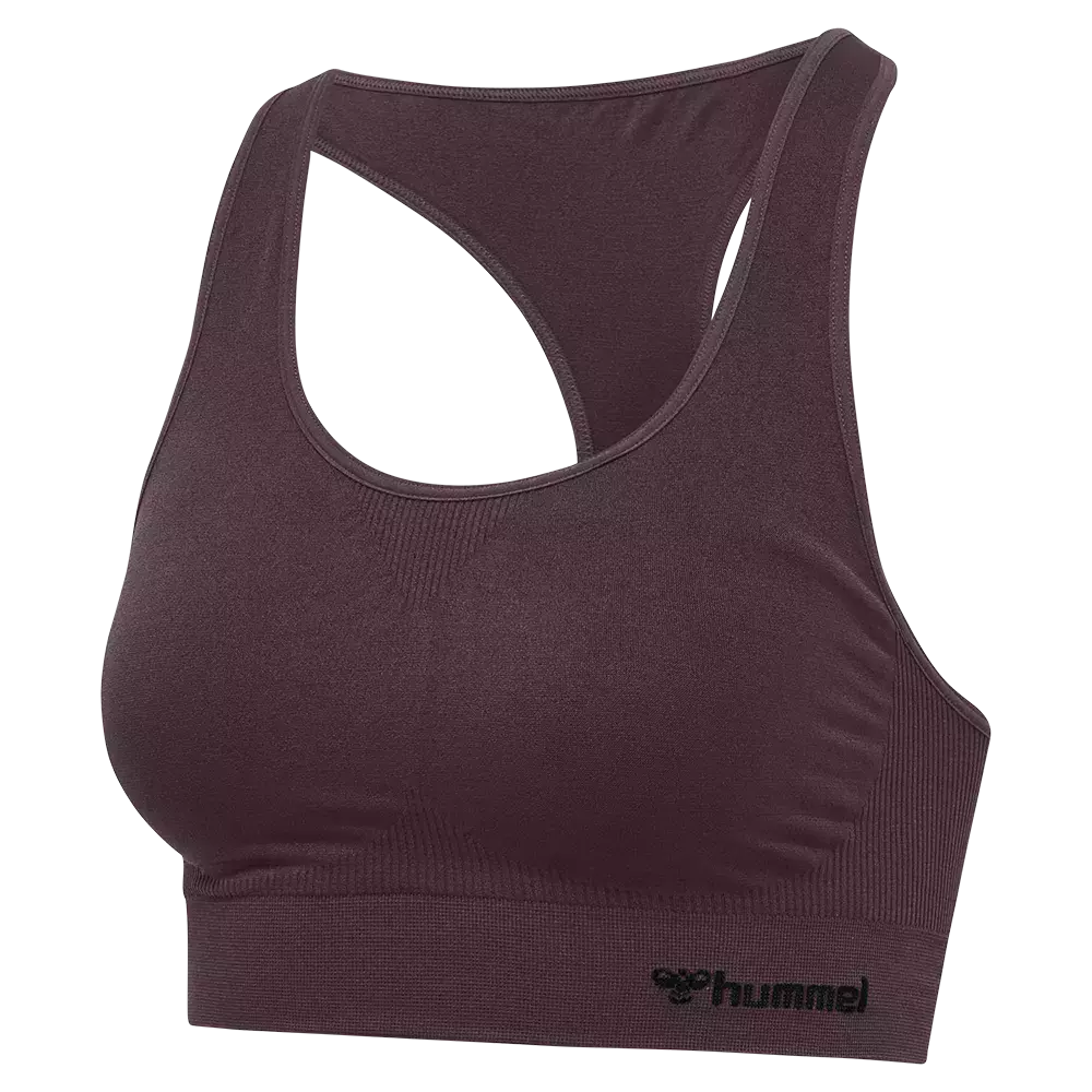 Den viste sports-bh i dyb plommefarve har et enkelt, funktionelt design med racerback og bred elastisk underkant for god støtte. Materialet ser strækbart og blødt ud med fint ribmønster ved siderne og under brystet, hvilket øger komforten og pasformen. Brede stropper og formsyede skåle sikrer stabilitet under træning, mens et diskret logo nederst giver et sporty finish. Velegnet til lav- til medium-intensitet.