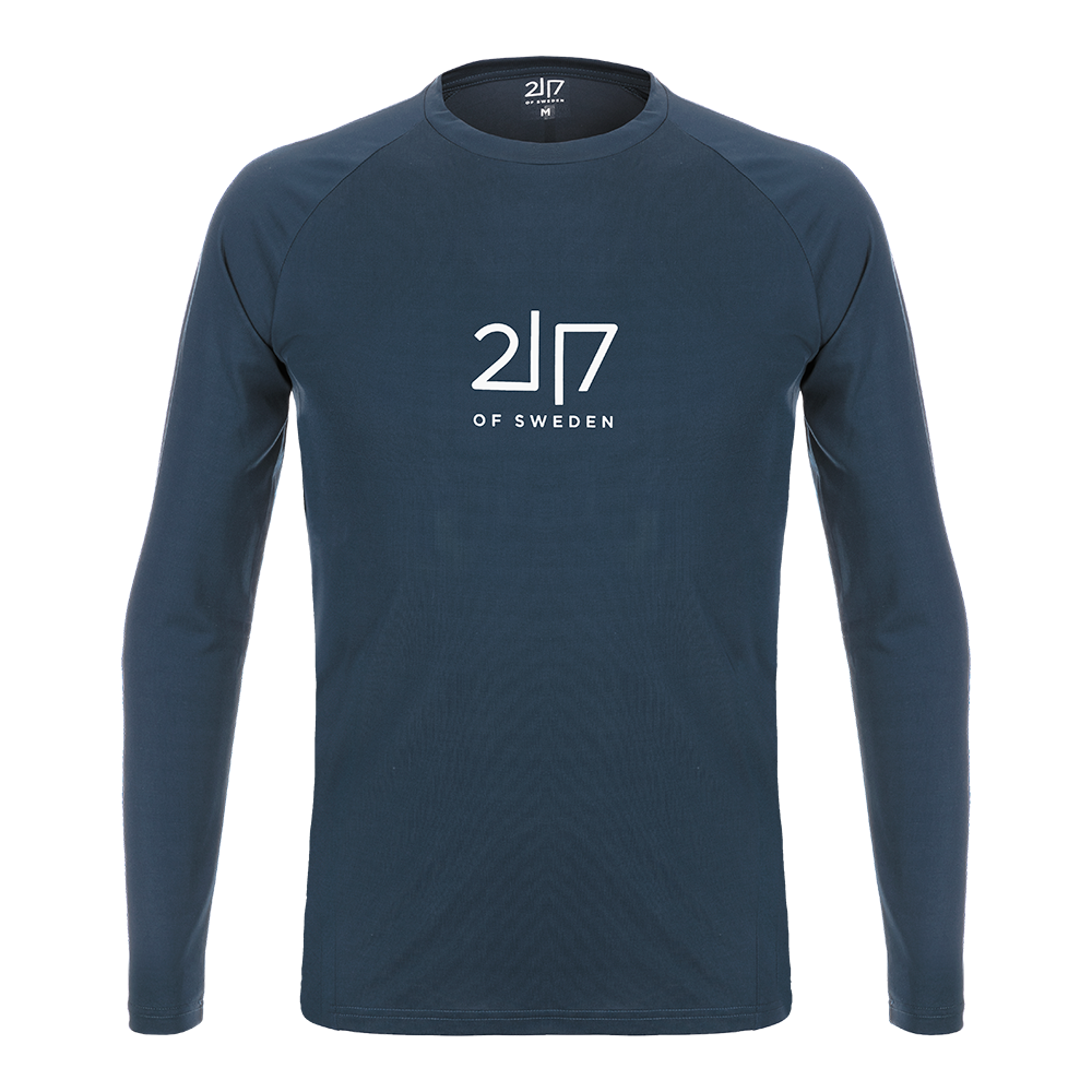 Langærmet T-shirt i dyb marineblå med rund hals og et enkelt, centralt hvidt logo ('2|7 OF SWEDEN') på brystet. T-shirten har raglanærmer og en slank, moderne pasform med rene syninger ved ærmer og kant. Designet fremstår minimalistisk og praktisk — velegnet til hverdag eller som lag-på-lag under jakker på kølige dage. Stoffet virker blødt og åndbart, og farven er alsidig og nem at kombinere.
