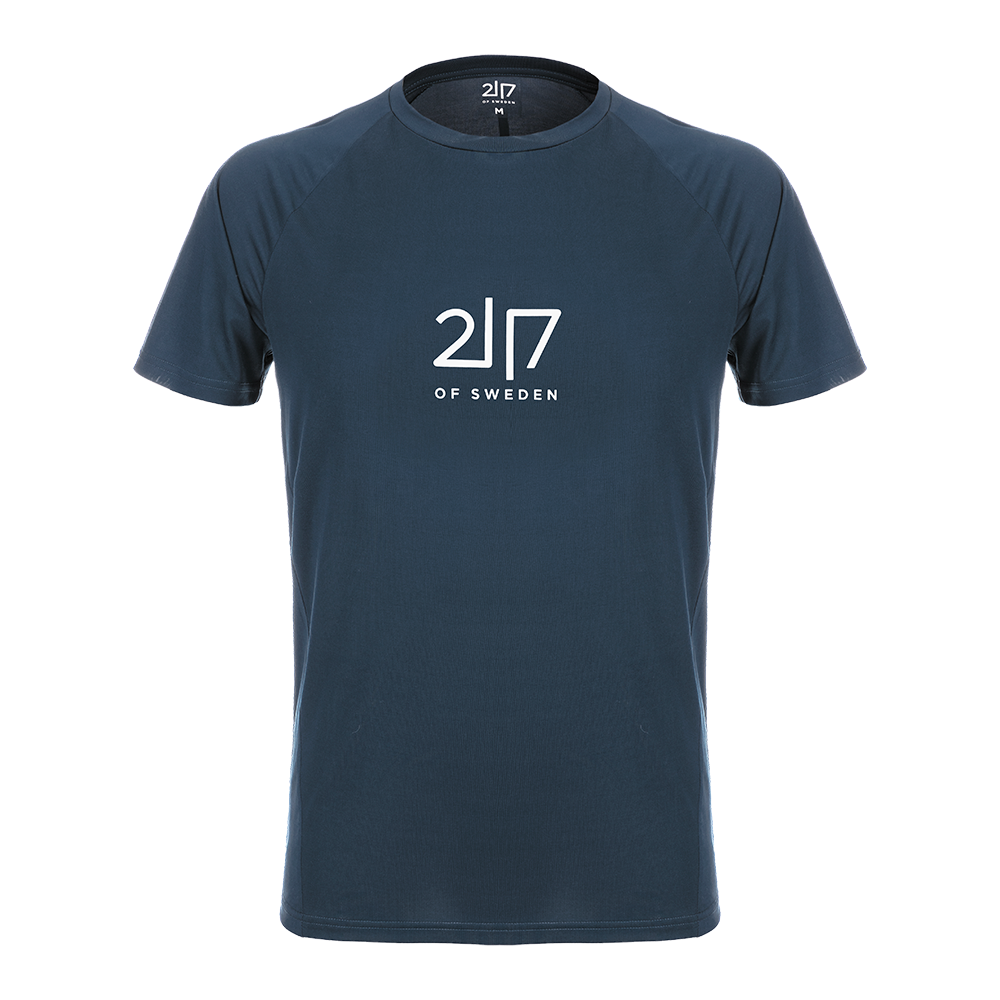 En enkel, navyblå T‑shirt med rund hals og korte raglanærmer. Fronten prydes af et minimalistisk, hvidt logo "2|7 OF SWEDEN", der giver et skarpt, skandinavisk udtryk. T‑shirten fremstår tætsiddende men afslappet, med et glat, let stof der ser behageligt og åndbart ud. Perfekt til hverdagsbrug eller lag-på-lag under jakker for et stilrent, sporty look.