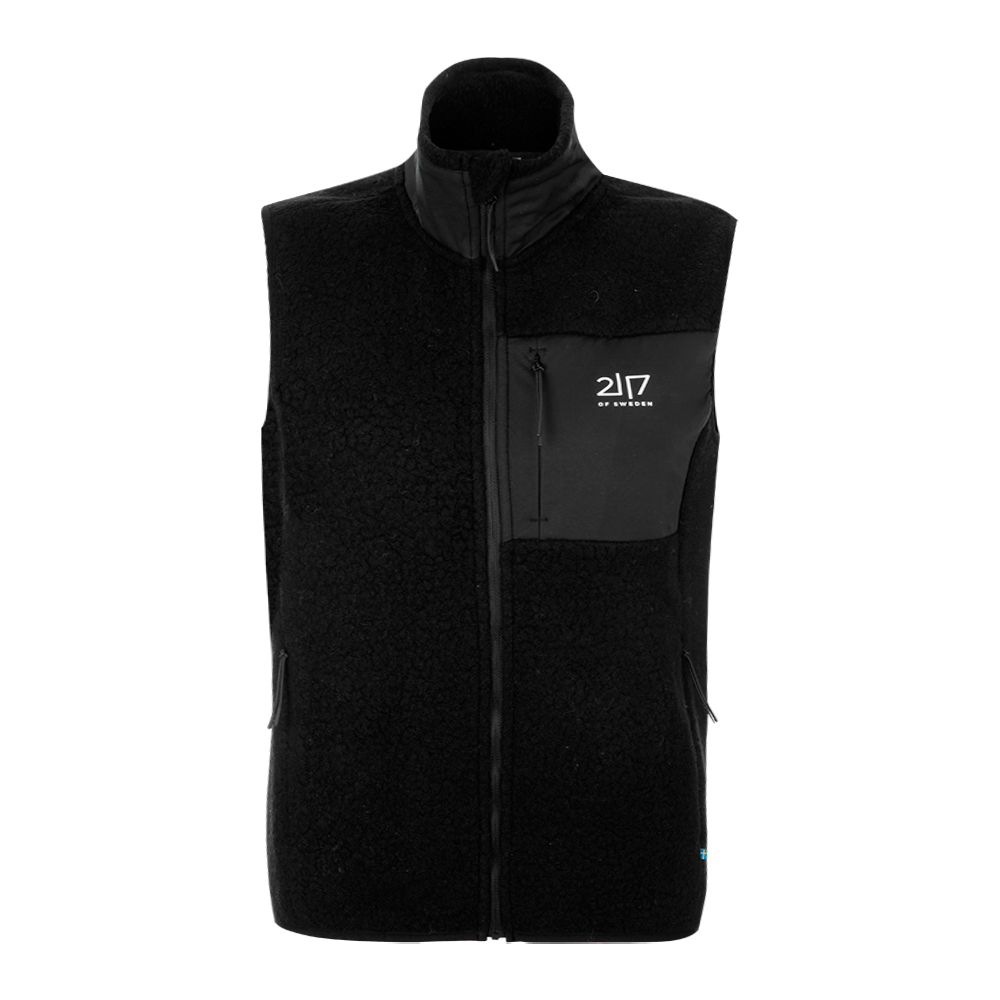 En sort fleecevest i klassisk, tidløs design med høj krave og fuld lynlås foran. Vesten har blødt, bouclé-lignende materiale, to sidelommer og en brystlomme med vandafvisende panel og lille logo fra 217 of Sweden. Den er varm og behagelig uden ærmer, ideel som mellemlag på kølige dage eller til outdoor-aktiviteter. Simpelt og funktionelt snit passer både til hverdag og aktiv fritid.