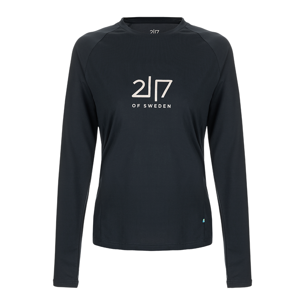 sort med rund hals og et enkelt, centreret logo "2|7 OF SWEDEN" på brystet. Skjorten har en minimalistisk, sporty silhuet og ser ud til at være syet i et teknisk, svedtransporterende materiale med let stretch. Et lille svensk flag i sømmen giver et diskret brandtouch. Perfekt til træning eller som hverdagstop.