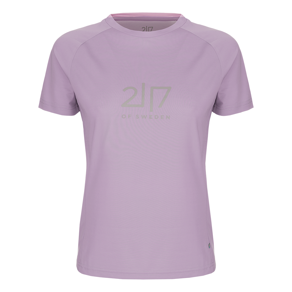 En enkel og stilfuld t-shirt i sart lyslilla nuance med kort ærme og rund hals. Modellen har en afslappet, let figursyet pasform og synlige sømme ved ærmerne, der giver et sporty udtryk. Midt på brystet sidder et diskret, ton-i-ton logo '2|7 of Sweden'. Stoffet fremstår blødt og teknisk, velegnet til hverdag, træning eller lag-på-lag-look i forårs- og sommermånederne.