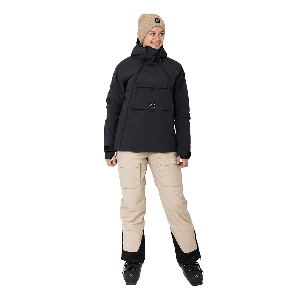 2117 of Sweden præsenterer Nelkerim Padded Ski Anorak, en højeffektiv dame skijakke designet til al slags vintervejr. Jakken er sort, har en stor frontlomme og justerbare manchetter, hvilket gør den både praktisk og stilfuld. Designet med en hætte og robust lynlås tilbyder den optimal beskyttelse og komfort på skibakken. Denne model forener funktionalitet med et moderne udseende, perfekt for den modebevidste skiløber.