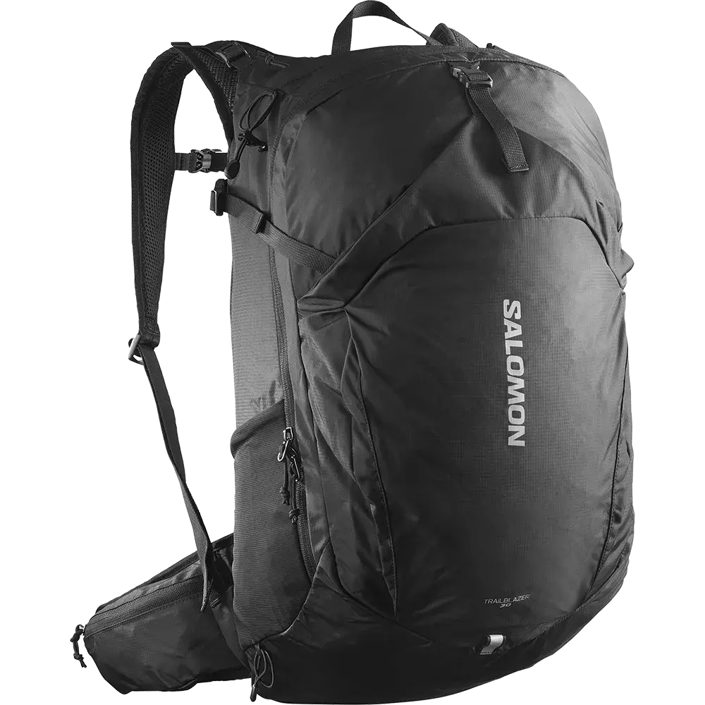 Sort Salomon-rygsæk med et slankt, sporty design og tydeligt logo på fronten. Den har polstrede skulderstroppe og et justerbart bryst- og hoftebælte, flere lynlåslommer og kompressionsstropper til stabilitet. Materialet virker robust og let, egnet til dagsture eller let vandring. Rygsækken fremstår rummelig og funktionel med praktiske lommer og ergonomisk form, der sikrer komfort ved længere ture.