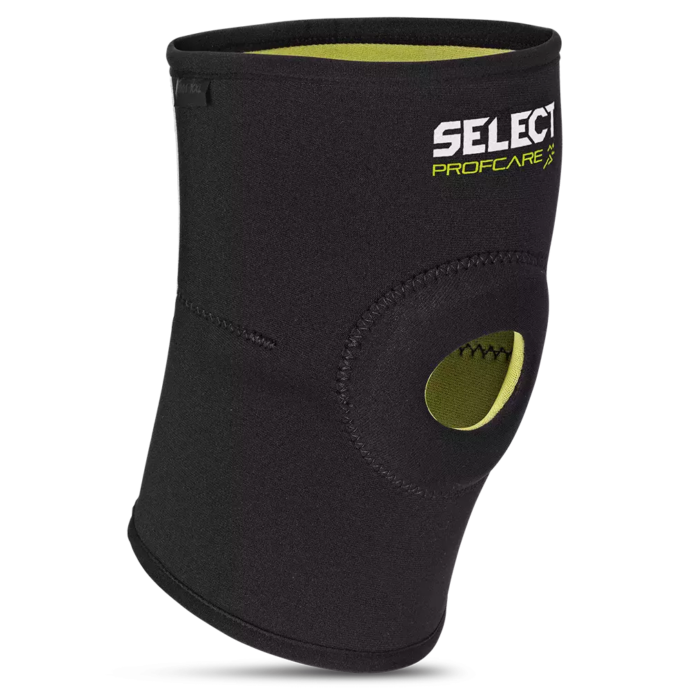 Sort neopren knæstøtte med grøn inderside og åben patella-løsning. Produktet har forstærkede sømme og et trykt "SELECT PROFCARE" logo, og er designet til anatomisk pasform omkring knæet. Den giver varme, let kompression og stabilisering ved sport, genoptræning eller lettere skader. Nem at tage på og justere, velegnet til forebyggelse af overbelastning og øget komfort under aktivitet.