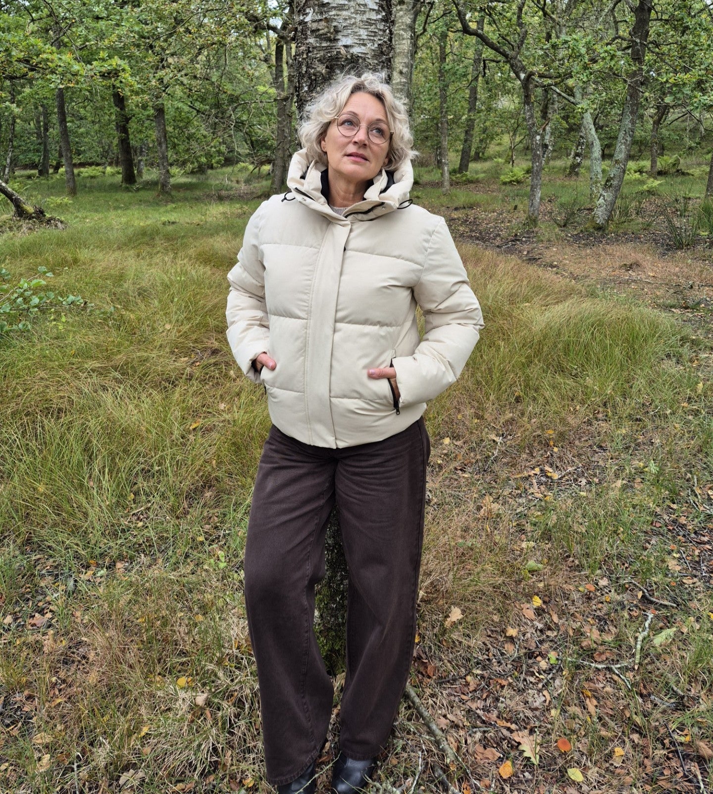 Dame med en hvid dame vinterjakke i en skov