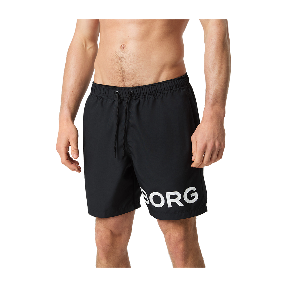 Et billede viser et mandligt overkropsudsnit iført sorte bade- eller træningsshorts med elastisk talje og snøre. Shortsene er midt på låret, med et stort hvidt print "BORG" på venstre ben. Stoffet virker let og hurtigtørrende, egnet til strand, pool eller træning. Modellen står afslappet med hænderne ned langs siderne. Stilen er enkel og sporty med fokus på komfort.
