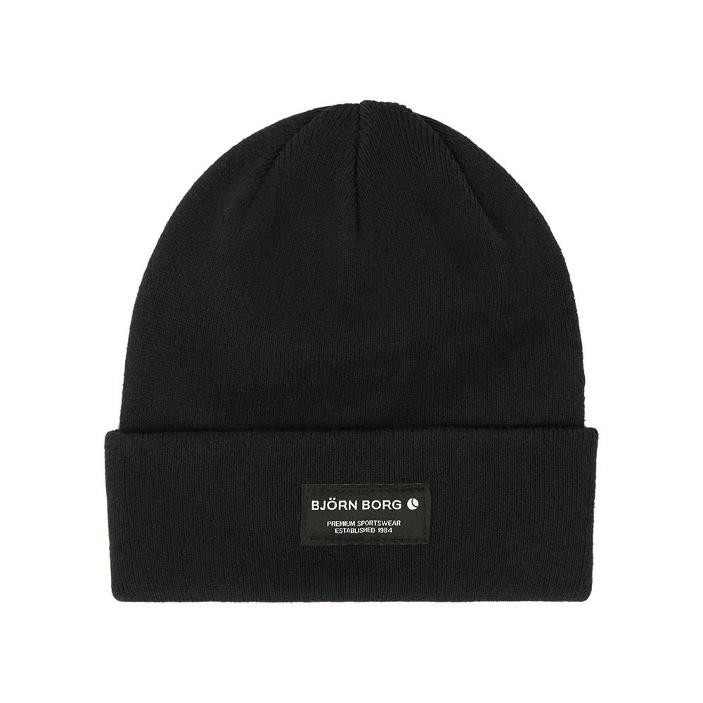 Sort, strikket beanie med opbukket kant og diskret mærke i front. Huen har et enkelt, minimalistisk udtryk; labelen viser "BJÖRN BORG" i hvid skrift mod mørk baggrund, hvilket giver et sporty og moderne præg. Den tætte strik og den klassiske form gør den velegnet til både hverdag og udendørs aktiviteter, og den passer nemt ind i en afdæmpet, urban garderobe.