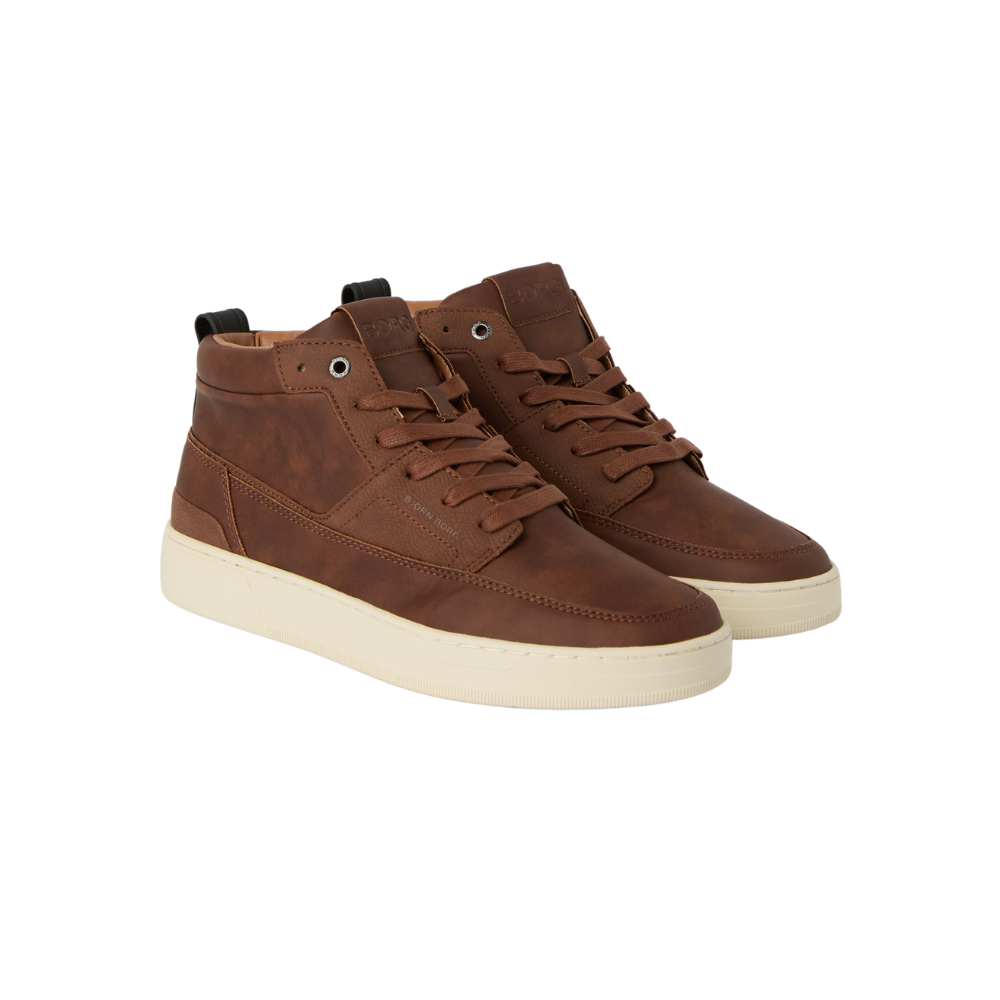 Et par stilfulde brunlige mid-cut sneakers i læderlook med lyse cremefarvede såler. Skoene har runde snørrebånd, forstærkede syninger og en polstret krave for komfort. Det enkle, tidløse design passer både til hverdag og casual outfits, og den robuste sål giver god støtte. Perfekte til efterårsbrug eller til at give et klassisk touch til afslappet påklædning.