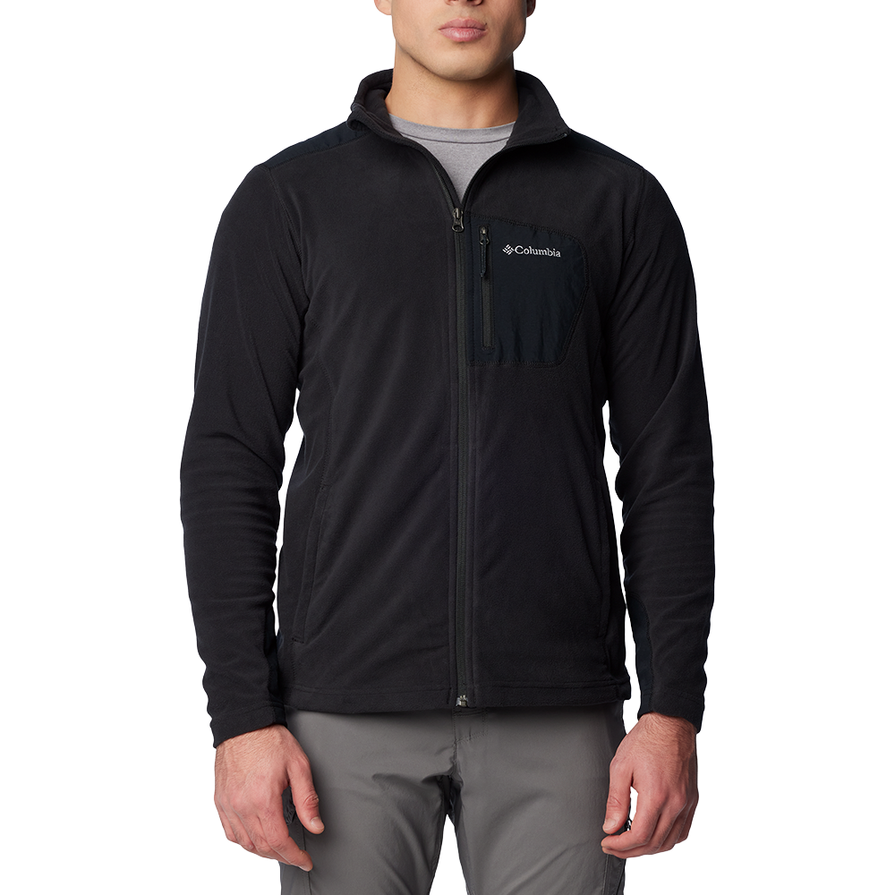 En mand iført en enkel, sort Columbia fleecejakke med fuld lynlås. Jakken har en brystlomme med lynlås og logo, høj krave samt blødt, tæt fleecemateriale der giver varme. Under ses en grå T‑shirt, og han bærer lysegrå bukser. Snittet er afslappet men tætsiddende, velegnet til udendørsaktiviteter eller som varm mellemlagsjakke på køligere dage.