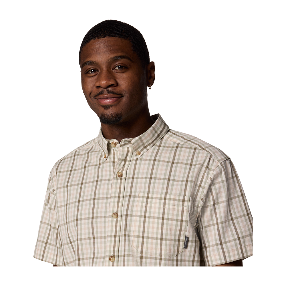 På billedet ser vi en ung mand iført Columbia Rapid River II skjorte, perfekt til sommerdage og rejser. Skjorten har en klassisk button-down krave og en praktisk brystlomme, som tilføjer et traditionelt touch. Det afslappede snit og det strækbare, komfortable materiale fremhøver skjortens anvendelighed i både bymiljøer og under udflugter. Ternmønsteret i dæmpede farver understreger et stilrent og alsidigt look.