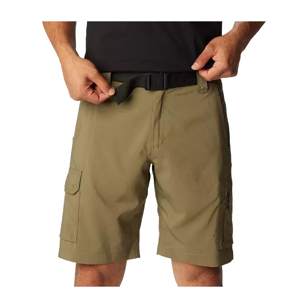 Et nærbillede viser en person i olivengrønne cargoshorts og et sort bælte, hvor hænderne justerer spænden. Shortsene er knælange med flere lommer, herunder en lomme med klap og en lynlåslomme, og har et robust, let materiale egnet til friluftsliv. Snittet er afslappet og funktionelt, med forstærkede syninger og en neutral farve, der passer til hverdags- og udendørsbrug.