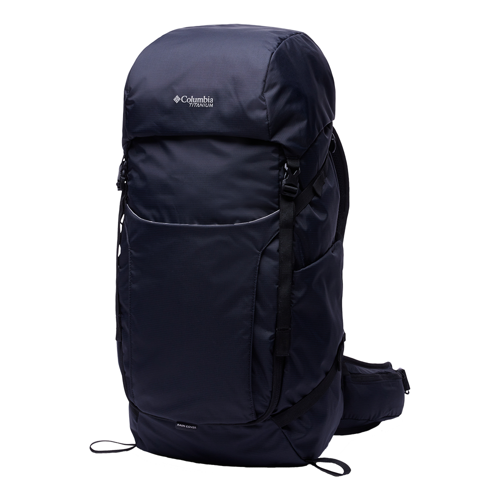 Mørkblå Columbia Titanium-rygsæk med et enkelt, funktionelt design til vandreture og rejser. Den har en stor topklap, rummelig frontlomme og kompressionsremme langs siderne for stabilitet. Polstrede skulder- og hoftebælter øger komforten ved længere ture, og en indbygget regncover-angivelse antyder vejrbeskyttelse. Materialet fremstår robust og vandafvisende, med et minimalistisk udtryk og praktiske detaljer til udendørs brug.