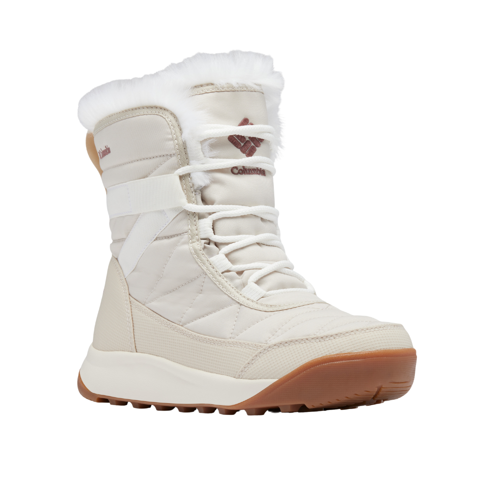 Vinterstøvlen er en høj, polstret model i lys cremefarve med blød hvid pelskant ved åbningen. Den har klassiske snørebånd, quiltede tekstildetaljer og en bred, kraftig gummisål i brunlig nuance for godt greb på glatte underlag. Designet kombinerer varme og komfort med et stilrent, funktionelt look, ideelt til kolde dage og udendørs brug.