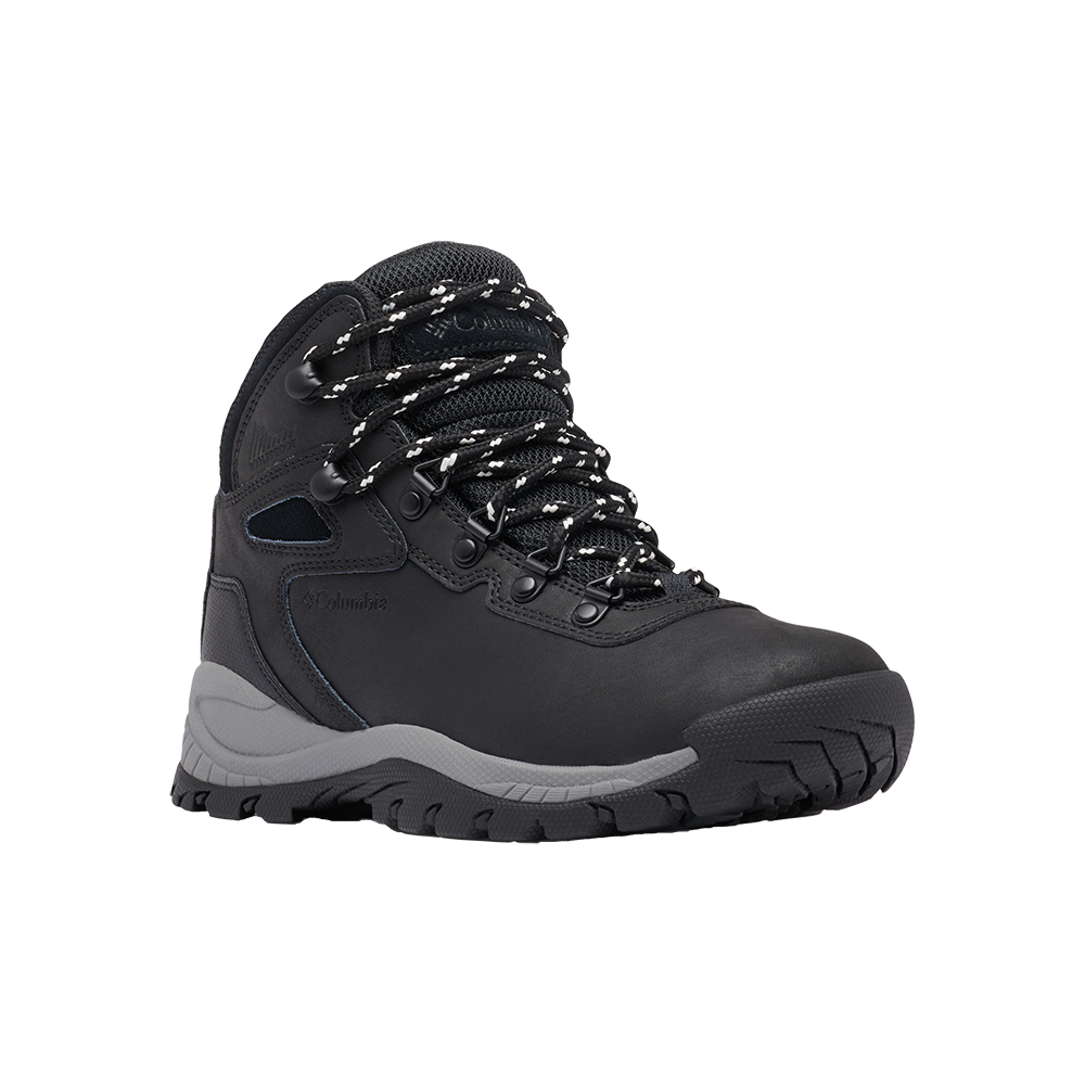 Billede viser en robust, sort vandrestøvle med høj ankelstøtte og kraftig, mønstret gummisål. Overdelen virker som ruskind eller slidstærkt læder med forstærkede sømme og polstret mesh ved skaftet. Snørebåndet er sort med hvide prikker og føres gennem metaløjer og hægter. Den grå mellemsål giver støddæmpning, mens det skridsikre profilmønster lover godt fodfæste i ujævnt terræn. Et praktisk og funktionelt outdoor-design.