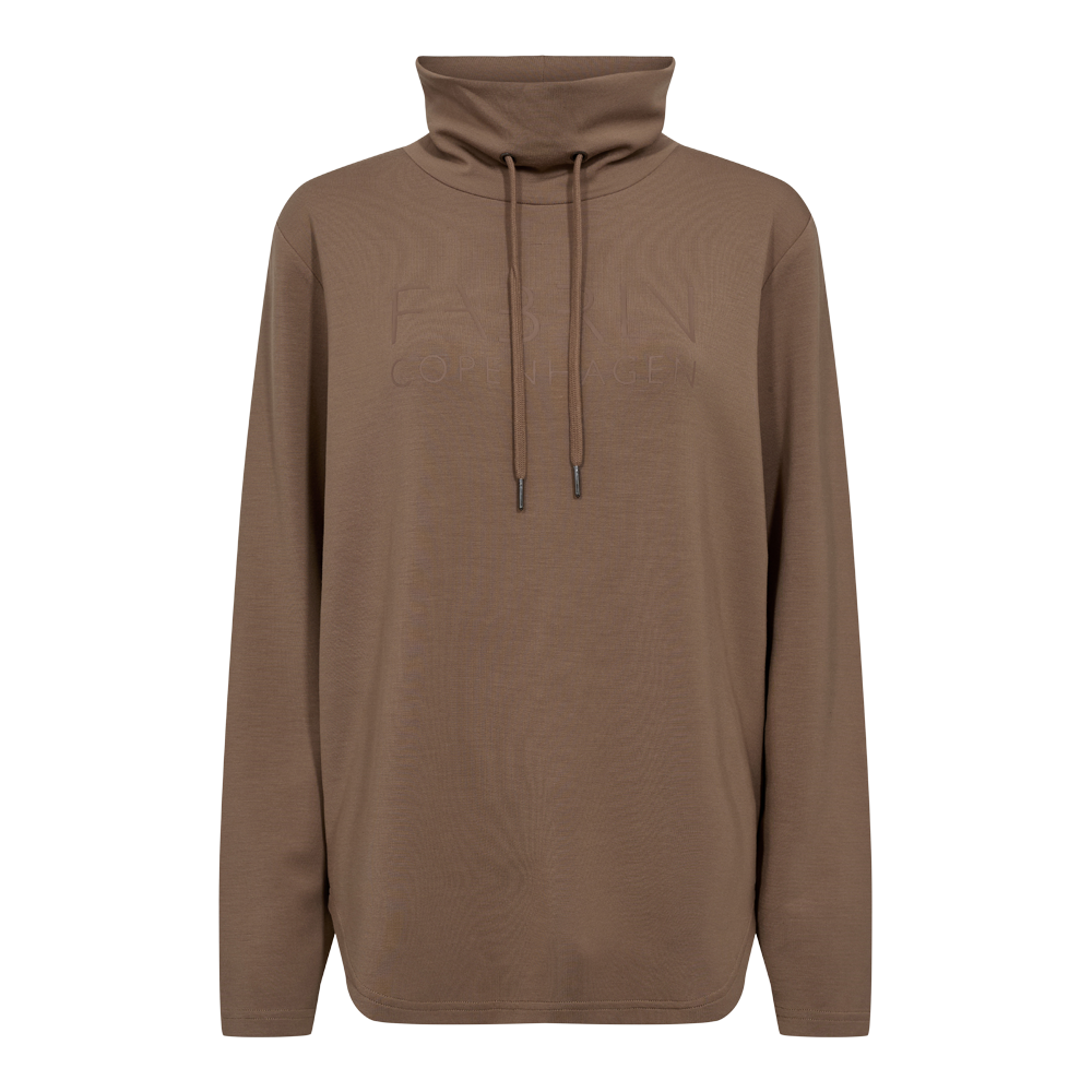 En enkel og tidløs turtleneck-trøje i varmt brun/taupe. Den har lange ærmer, en løs pasform og en høj rullekrave med justerbare snore, der giver et afslappet udtryk. Materialet fremstår blødt og behageligt med en let struktureret overflade, mens den ton-i-ton, diskrete logo-embossing på brystet holder designet minimalistisk. Perfekt til lag-på-lag om efteråret og til afslappede hverdagslooks.