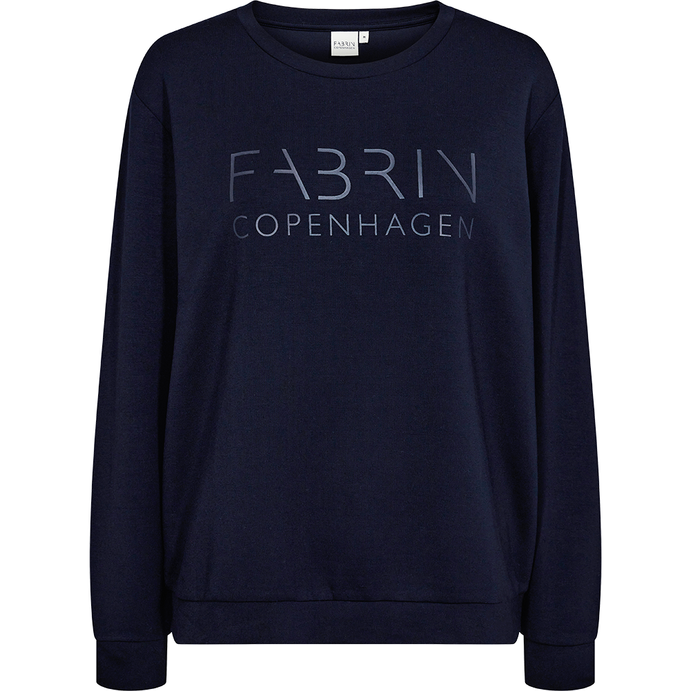 En enkel og moderne mørkeblå sweatshirt med rund hals og lange ærmer. Brystet prydes af diskret, lysere tryk med teksten "FABRIN COPENHAGEN", som giver et stilrent nordisk udtryk. Materialet ser blødt og lidt tungt ud, egnet til hverdag og afslappede outfits. Ribkanter ved ærmer og bund sikrer god pasform. Perfekt til lag-på-lag eller som minimalistisk statement i garderoben.
