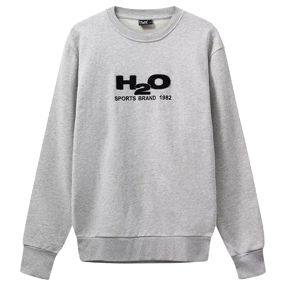 Lysegrå sweatshirt med rund hals og afslappet pasform. Trøjen har lange ærmer, ribstrikkede manchetter og kant forneden, der giver et klassisk look. På brystet ses et sort, broderet logo "H2O SPORTS BRAND 1982", som tilføjer et sporty og retro præg. Stoffet ser blødt og fleecet ud, velegnet til hverdag, fritid eller lag-på-lag i køligt vejr.