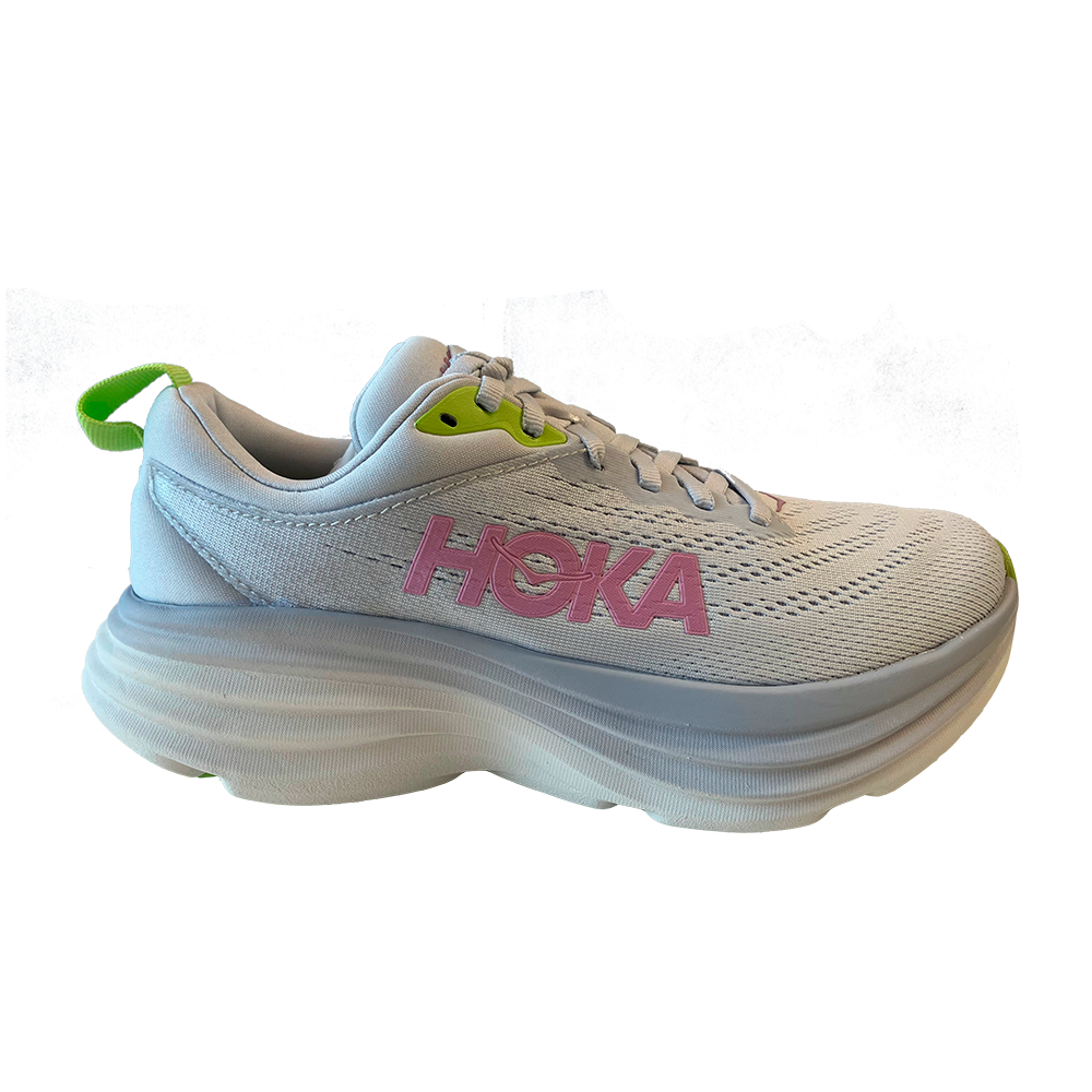 Et ensfarvet, lyst løbesko fra HOKA med markant lyserødt logo på siden og små neongrønne detaljer ved snørehuller og hælkappe. Overdelen er i åndbart mesh med subtile perforeringer, mens den kraftige, bølgende mellemsål giver ekstra affjedring og højde. Skoen har klassisk snørebånd, polstret krave og en praktisk hæl-loop, hvilket giver et moderne, komfortorienteret og stabilt udtryk til både træning og hverdag.