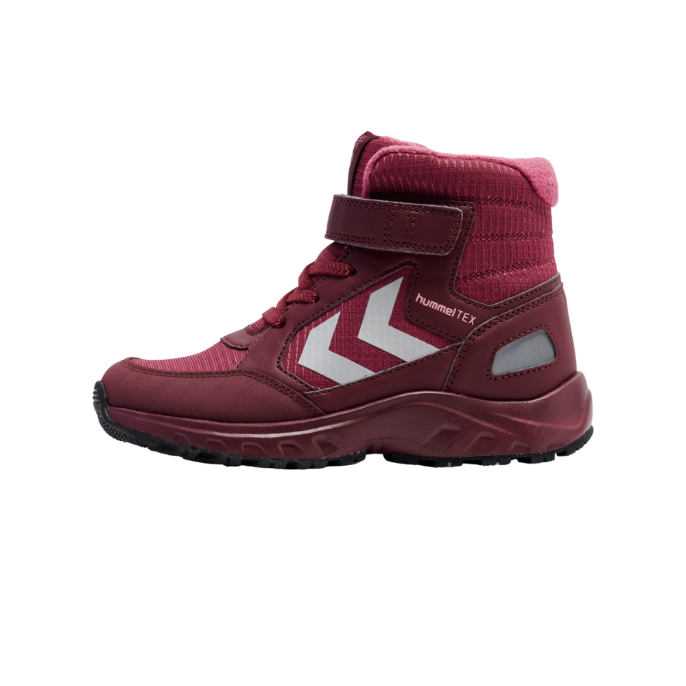 Denne børnestøvle i dyb bordeaux/rosa kombination er robust og sporty. Den har et mellemhøjt skaft med polstret inderside, snørebånd plus en praktisk velcrorem for nem lukning. Siderne viser reflekterende detaljer og markante hvide pile, og teksten "hummelTEX" antyder teknisk, vandafvisende materiale. Sålen er kraftig med godt mønster og giver god komfort og varme til udendørs leg.