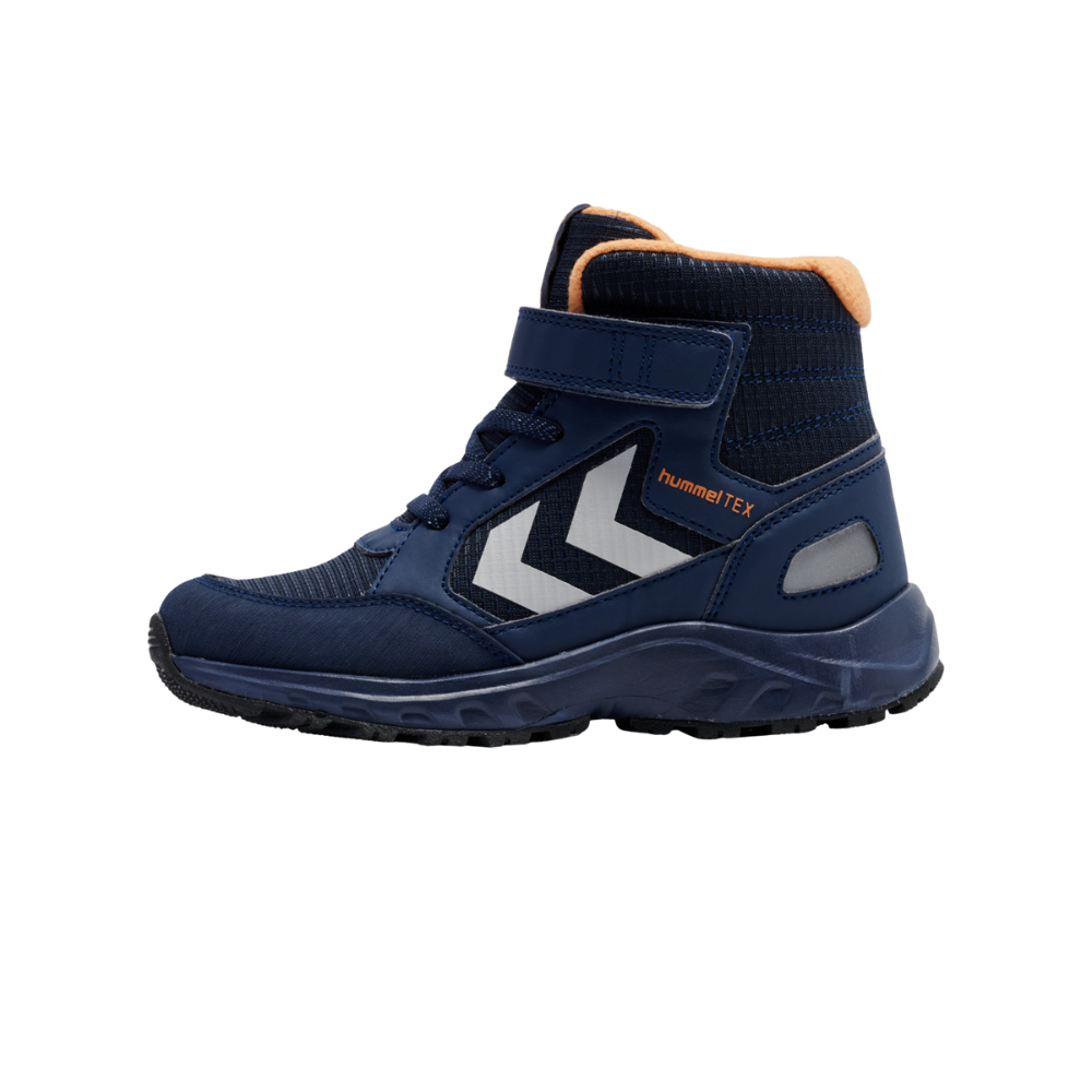 En mørkeblå børrestøvle i høj top med praktisk velcrolukning og snørebånd. Skoen har refleksive hvide chevron-striber på siden, orange indvendig polstring og tydelig hummelTEX-logo. Sålen er robust med dybt mønster til godt greb, mens materialet virker vandafvisende og slidstærkt. Designet kombinerer funktionalitet og sporty stil, velegnet til aktive børn i al slags vejr.