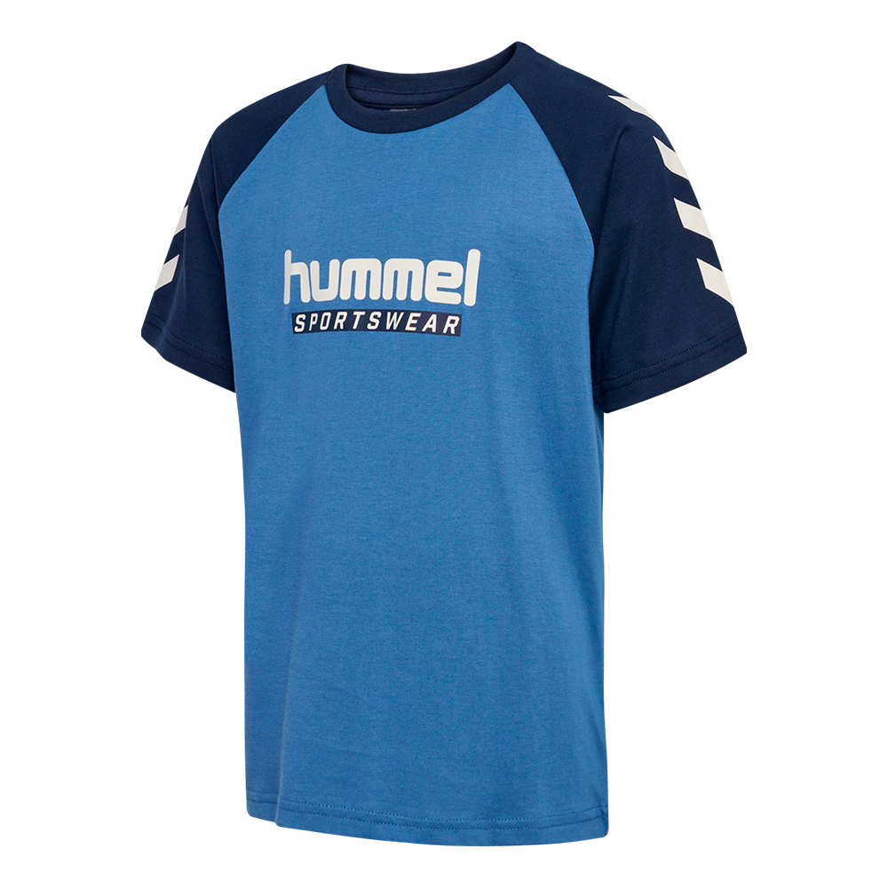 Blå hummel T-shirt med mørkeblå raglanærmer og rund hals. Fronten prydes af hvidt "hummel SPORTSWEAR"-logo, mens de ikoniske hvide chevrons på ærmerne giver et sporty udtryk. T-shirten har enkelt, tidløst design og ser ud til at være fremstillet i blødt, åndbart bomuldsblanding. Velegnet som hverdagstøj eller til træning, kombineres nemt med jeans eller træningsbukser for et afslappet look.
