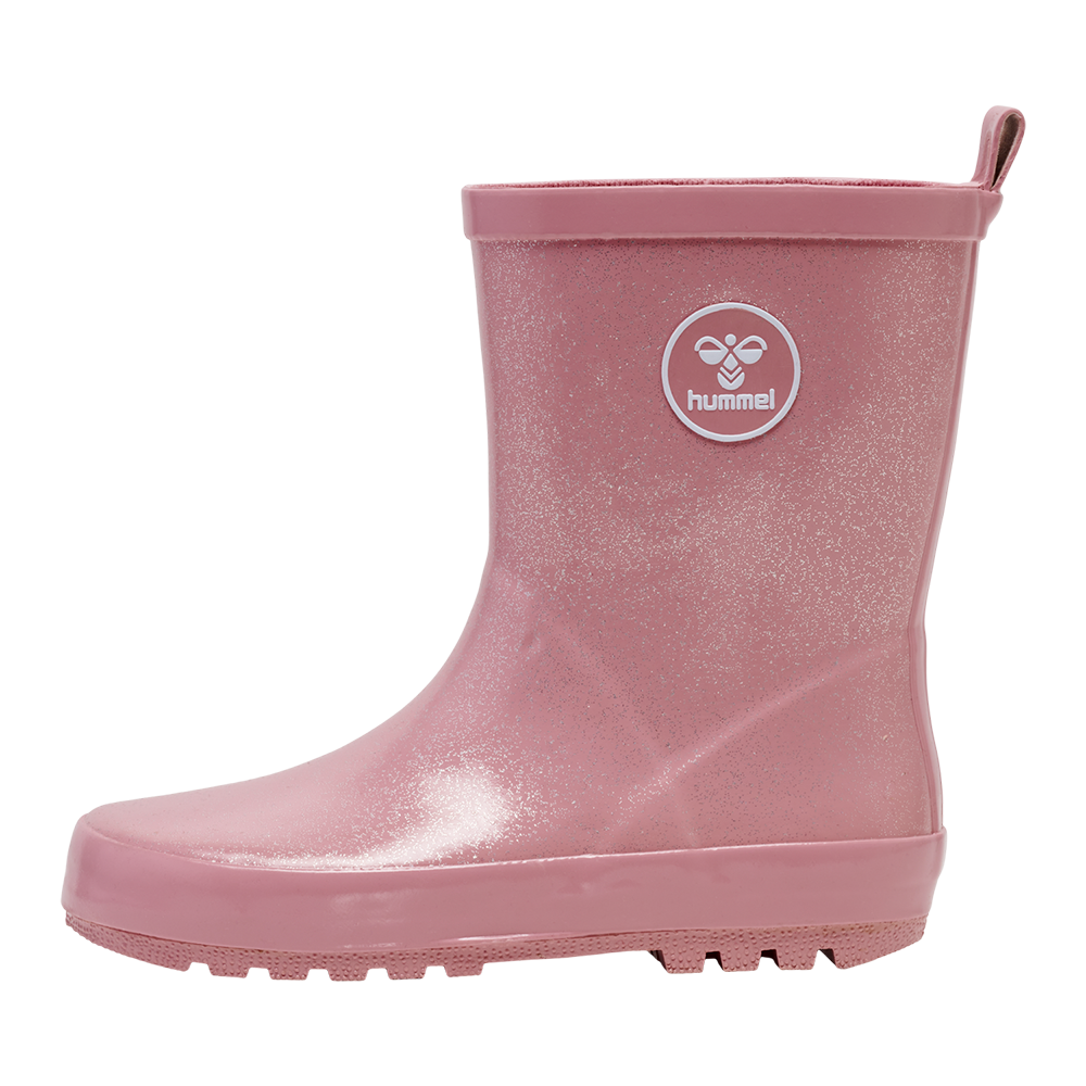 Rosa gummistøvle med en skinnende, glitrende overflade og enkel silhuet. Støvlen har et rundt Hummel-logo på siden og en praktisk trækstrop bagtil for nem påtagning. Den er fremstillet i vandtæt materiale med solid sål og rillemønster for godt greb i mudder og regnvejr. Et stilfuldt og funktionelt valg til børns leg ude i vådt vejr.