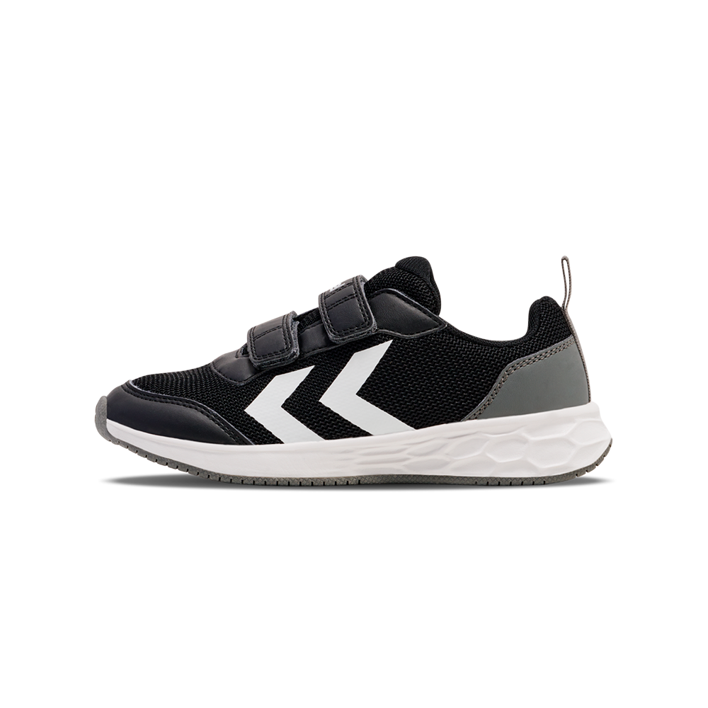 En moderne, sportssko i sort med to hvide pilformede striber langs siden. Overdelen har åndbart mesh og syntetiske forstærkninger, mens to velcroremme gør den nem at tage på og af. Skoen har en polstret krave, grå hælforstærkning og en hvid, stødabsorberende mellemsål med tekstur. Et praktisk og stilrent valg til hverdag og leg.