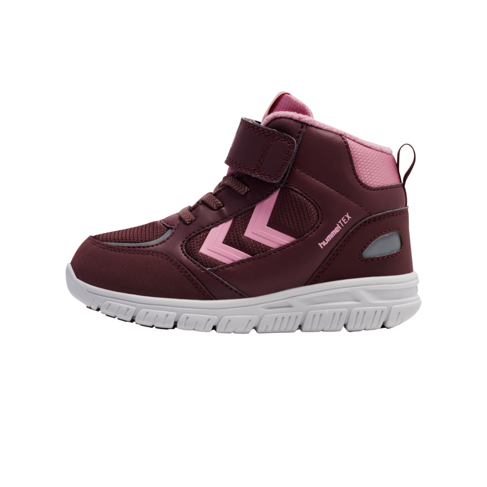 En børnesneaker i dyb burgunder med lyserøde detaljer, en hvid fleksibel gummisål og høj ankellukning. Skoen har velcrolukning øverst, snørelignende detaljer, meshpaneler for åndbarhed og en polstret krave for ekstra komfort. Siderne prydes af lyserøde chevrons og hummelTEX-logo, hvilket antyder vandafvisende egenskaber. Et praktisk design til aktive børn, der kombinerer støtte, komfort og synlighed.