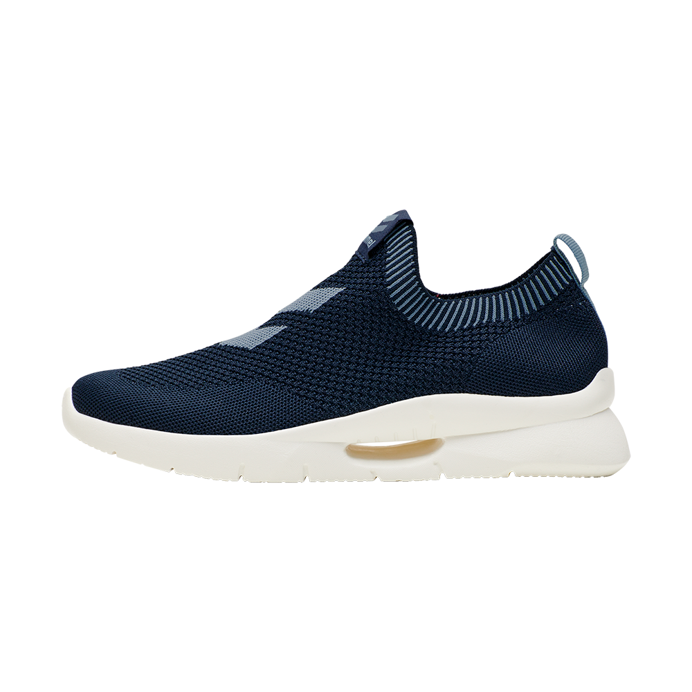 Billedet viser en moderne slip-on løbesko i mørkeblå strik. Overdelen er åndbar og sømløs med et vævet mønster, mens den elastiske krave sikrer nem af- og påtagning. Skoens hvide mellemsål er let og støddæmpende med en synlig luftpude i siden for ekstra komfort. Designet fremstår minimalistisk og sporty, velegnet til hverdag og træning, og kombinerer funktionalitet med stil.
