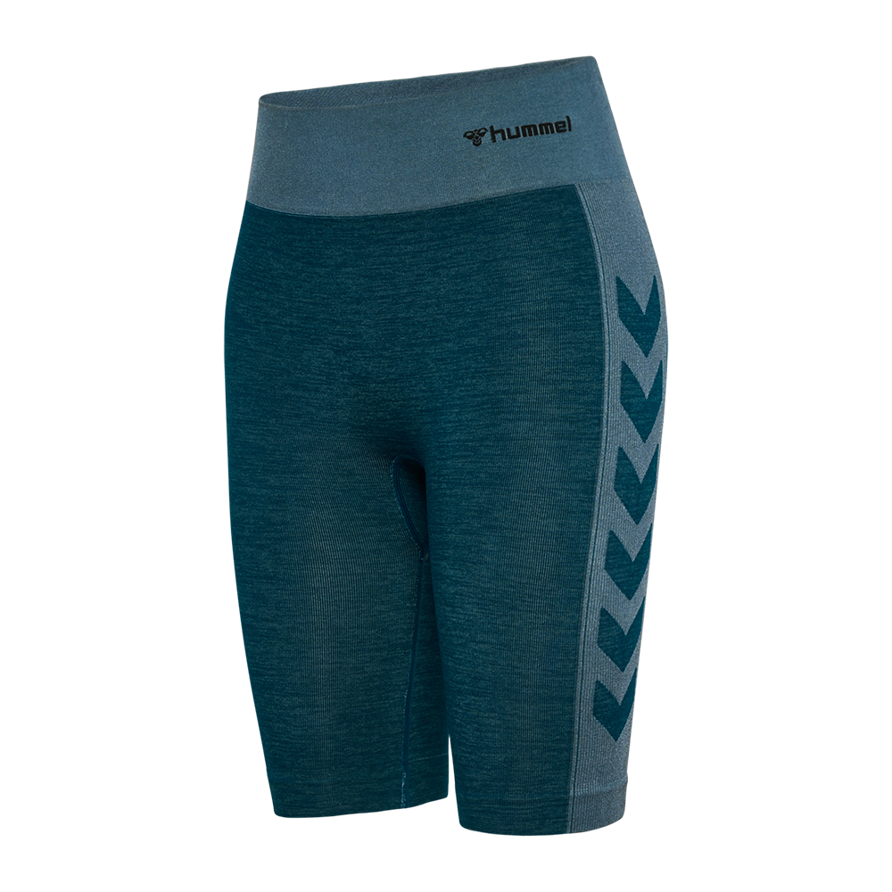 Disse korte træningsshorts fra Hummel er i en dyb petrolgrøn med en kontrastfarvet grå talje, der giver støtte og høj komfort. Sømløs, elastisk pasform følger kroppens linjer og når midt på låret. Siderne prydes af Hummels karakteristiske chevrons. Ideelle til løb, cykling eller styrketræning, hvor bevægelsesfrihed og åndbarhed er vigtige.