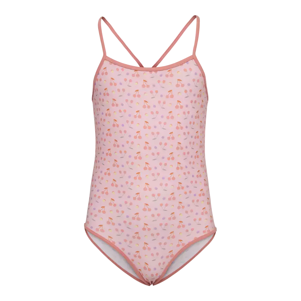Badedragt i ét stykke til børn i lys rosa med et fint, gentaget mønster af små kirsebær og prikker i forskellige pastelfarver. Den har tynde, krydsede skulderstropper og kontrastkant i koral rundt om ærmegab og ben. Stoffet ser blødt og elastisk ud, velegnet til leg i vandet, og designet er både sødt og praktisk til strand- eller poolbrug.