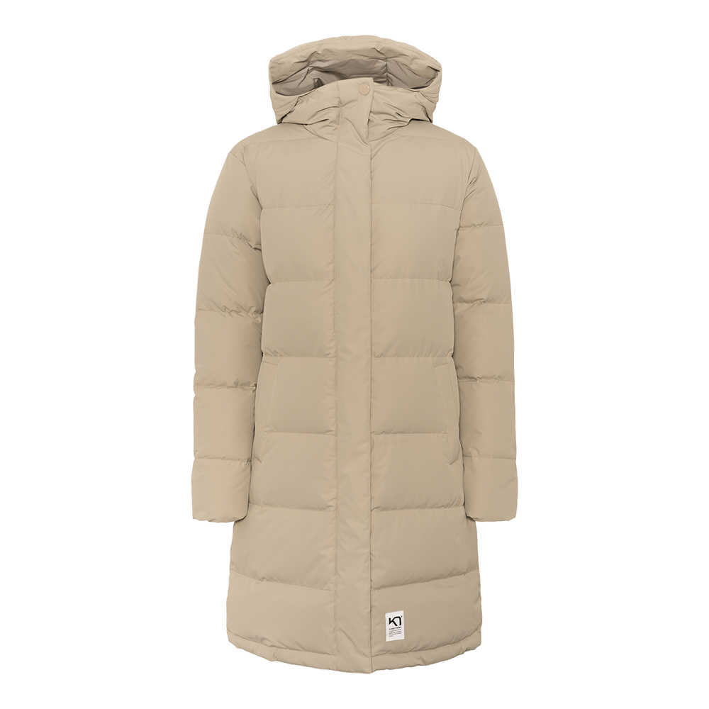 Lang, vatteret frakke i en varm beige tone med hætte og skjult lukning. Den enkle, quiltede konstruktion giver et rent, tidløst udtryk, mens sidelommerne og længden sikrer funktionel varme på kolde dage. Frakken virker kønsneutral i snittet og er ideel til hverdag eller byliv, hvor komfort og diskret stil prioriteres.