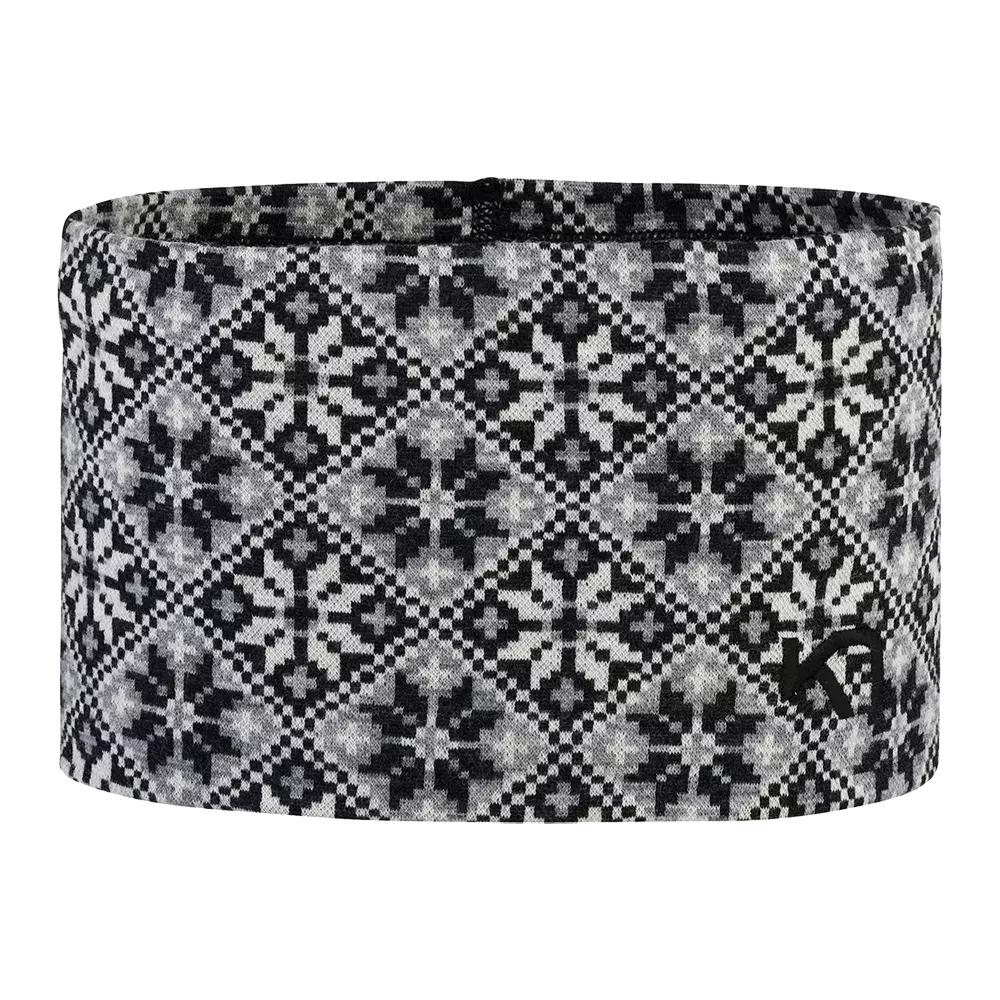Et stilrent, sort-hvidt pandebånd med nordisk-inspireret mønster. Det elastiske stof har gentagne geometriske stjerner og små ruder, som skaber et klassisk, strikket udseende. Pandebåndet virker varmt og blødt, velegnet til kolde dage og udendørs aktiviteter. Det neutrale farveskema gør det let at kombinere med vinterjakker, huer eller tørklæder, og den tætte pasform beskytter pande og ører mod vind.