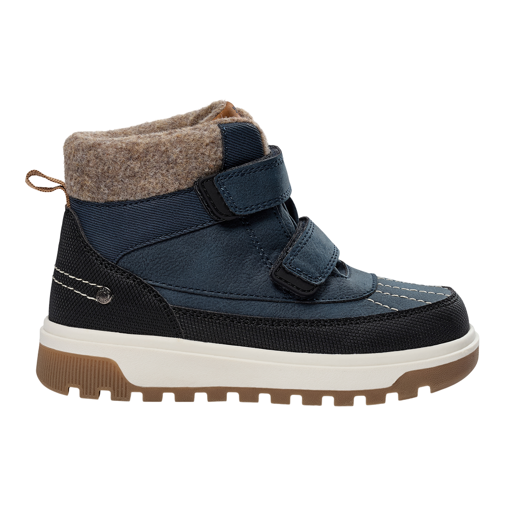 Fotografiet viser en robust, vandafvisende vinterstøvle i mørkeblå og sort med lyse kontrastsyninger. Støvlen har to brede velcrolukninger, en blød uldagtig fortykning ved skaftet og en lille trækkrog bagpå. Den kraftige hvide mellemsål og rillede brune gummiydersål giver god stød- og skridsikring. Designet kombinerer funktionalitet og komfort, velegnet til børn eller voksne, der har brug for varme og stabilitet i koldt vejr.