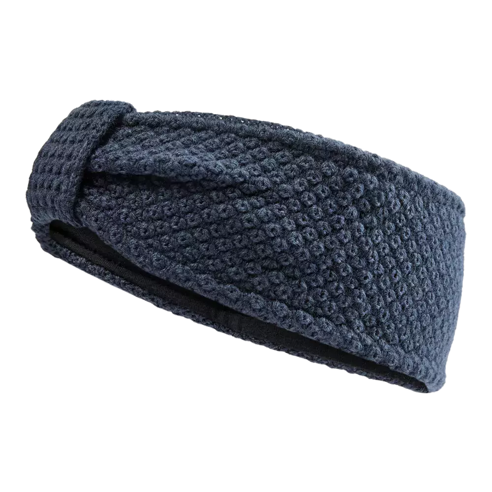 Et mørkeblåt, bredt pandebånd i kraftig, kornet strik med en diskret knudedetalje foran. Den tætte struktur giver et varmt og rustikt udtryk, mens den sorte indvendige foring sikrer blød komfort mod huden. Pandebåndet er ideelt til kolde dage, holder ørerne varme uden at fylde, og passer til både hverdag og aktive udendørsaktiviteter. Det stilrene design gør det nemt at kombinere med jakker og huer.