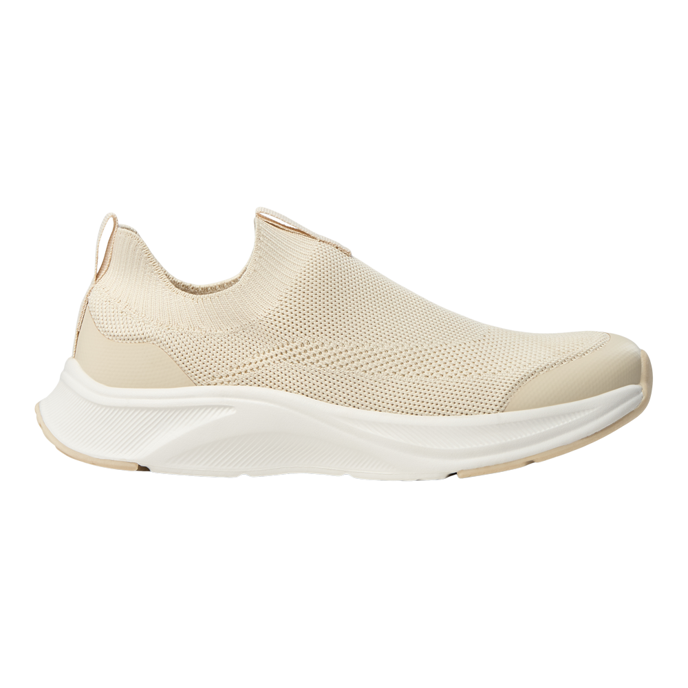 En elegant, lysebeige slip-on-sneaker med strikket overdel og blødt, polstret skaft. Skoen har en åndbar, tekstureret overflade, forstærket tå og en kraftig, hvid EVA-sål med let buet profil for støddæmpning. Minimalistisk design, elastisk pasform og bageste trækflap gør den nem at tage på. Velegnet til hverdagsbrug, gåture og afslappede outfits. Den neutrale farve passer til mange stilarter.