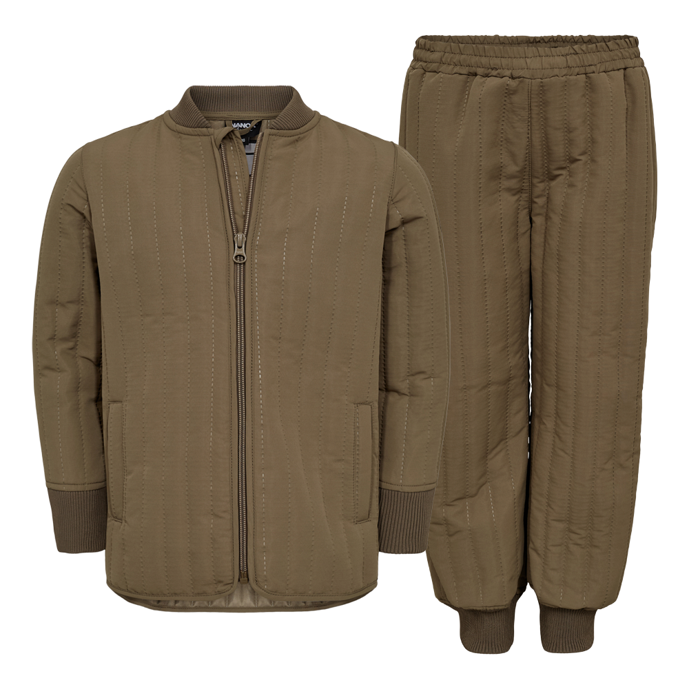 Dette sæt består af en quiltet jakke og matchende bukser i varm khaki-brun farve. Jakken har en central lynlås, diskrete lommer og ribafslutninger ved ærmerne, mens bukserne har elastik i taljen og ribmanchetter ved anklerne. Det bløde, polstrede materiale og lodrette syninger giver både varme og et moderne, minimalistisk udtryk—perfekt til afslappet hverdag og kølige dage.