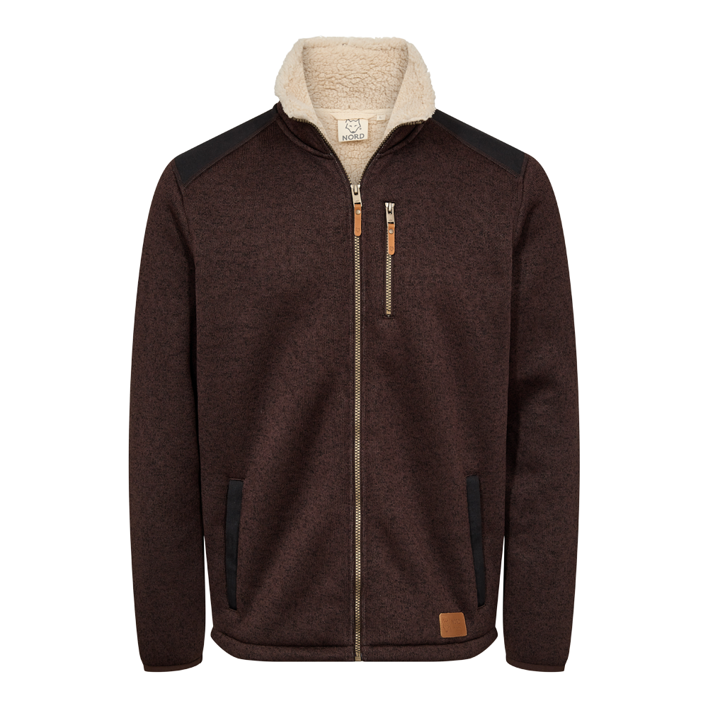 En mørkebrun, meleret fleecejakke med cremefarvet sherpa-for i kraven, der giver et varmt, rustikt udtryk. Jakken har en kraftig messinglynlås, en lodret brystlomme med lynlås samt to sidelommer. Sorte forstærkninger på skuldre og lommekanter og små læderdetaljer ved lynlåse samt en nederst placeret læder-patch fuldender designet. Perfekt som praktisk overgangsjakke til efterår og vinter.