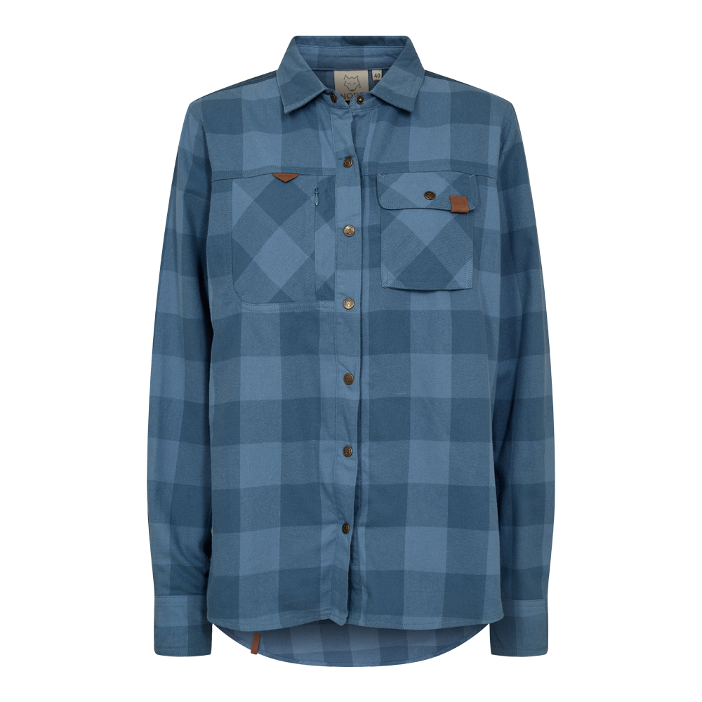 Skjorten er en afslappet, langærmet button-down i flannel-look med stort ternmønster i nuancer af blå. Den har klassisk skjortekrave, knaplukning hele vejen og to brystlommer, hvoraf den ene har klap og dekorativ lærdetalje. Stoffet virker blødt og varmt med let afrundet kant, hvilket giver et casual og funktionelt udtryk, velegnet til hverdag og udendørsbrug.