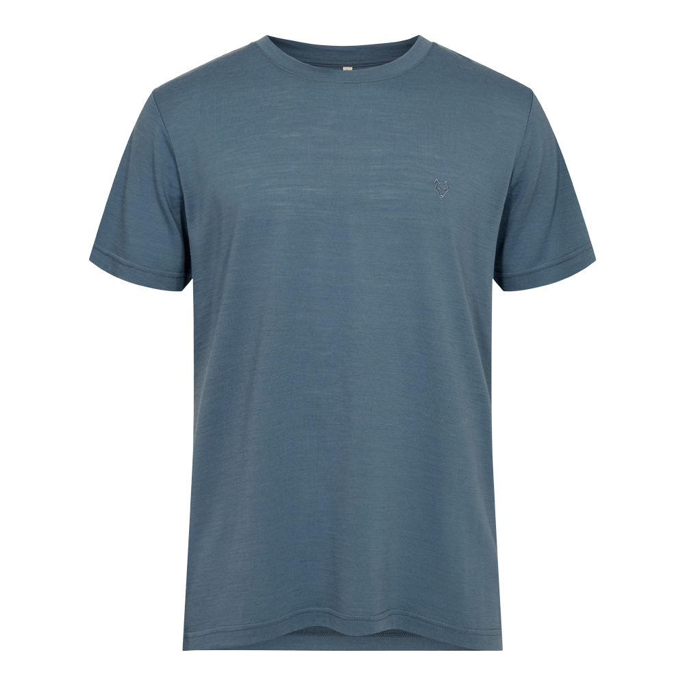 Blågrøn T-shirt med rund hals og korte ærmer i et enkelt, tidløst snit. Stoffet virker blødt og let med en fin, næsten meleret struktur, der giver dybde til farven. Et diskret, lille logo i form af et rævehoved pryder venstre bryst uden at dominere. Perfekt til hverdagsbrug og nem at kombinere under jakker eller til jeans og shorts.