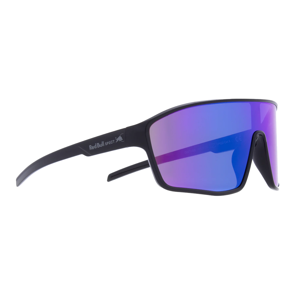 Solbrillerne i billedet er sportsinspirerede med et stort, buet shield-glas i reflekterende blå-lilla og en mat sort stel. Designet er aerodynamisk med brede stænger og en høj næsebro, som giver god dækning og vindbeskyttelse. De fremstår både robuste og lette, velegnede til cykling og outdoor-aktiviteter, mens det minimalistiske udtryk giver et moderne og funktionelt look.
