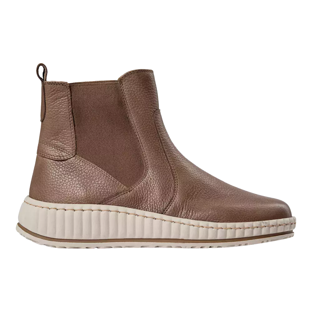 Brun Chelsea-støvle i præget læder med elastiske sider og trækstrop bagtil. Designet kombinerer en klassisk ankelhøjde med en moderne, ribbet hvid gummisål, der giver højde og komfort. Overfladen har synlige sømme og en robust struktur, hvilket skaber et afslappet, men stilrent udtryk. Perfekt til hverdagsbrug, let at kombinere med jeans eller kjole for et smart-casual look.