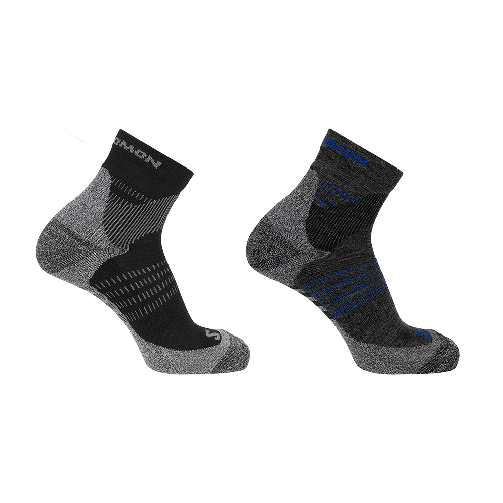Billedet viser to ankelhøje træningssokker i teknisk design, fremstillet i en blanding af grå og sort med kontrastdetaljer i blå. Sokkerne har strikkede zoner til ventilation, ekstra polstring ved hæl og tå samt elastiske ribkanter for bedre pasform. Det minimalistiske mønster og de forstærkede områder antyder holdbarhed og komfort, velegnet til løb, vandreture eller daglig aktivitet.