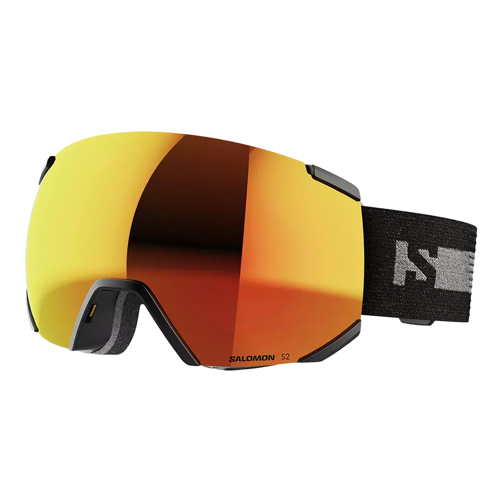 Salomon S2-skibriller med stor, sfærisk linse i varm orange- og kobberrefleksion, der dækker ansigtet bredt for maksimal udsyn. Rammen er sort og diskret, med blød skumforing ved næsen og en bred, elastisk rem i sort med logo. Brillerne giver et stilrent, teknisk udtryk og er velegnede til alpin skiløb og snowboard, hvor kontrast og beskyttelse mod sol og sne er vigtig.